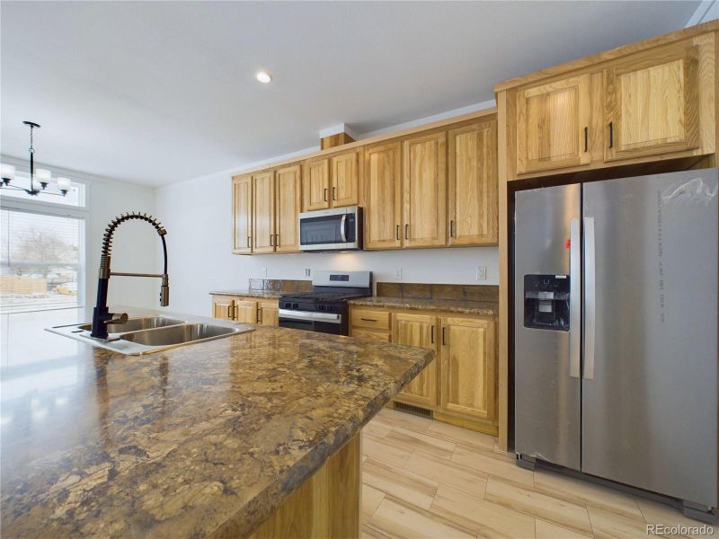 Kitchen with maple shaker cabinets dark pulls...