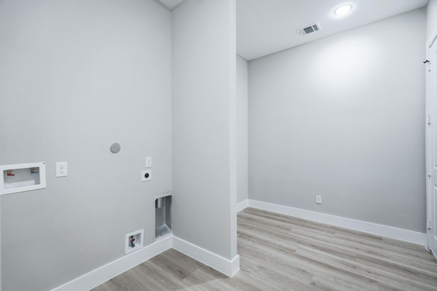Dedicated utility room with built-in storage and washer/dryer connections
