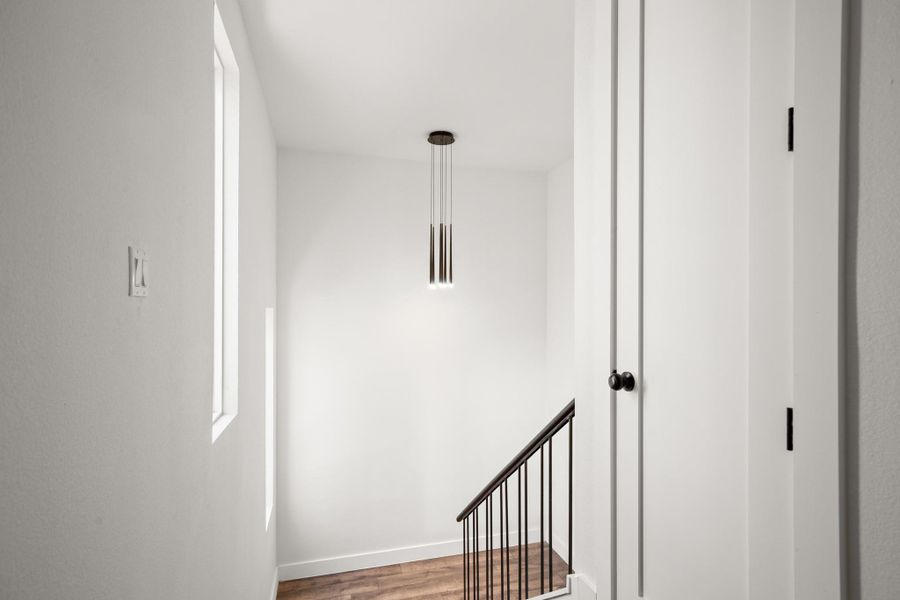 Stairs with wood finished floors and baseboards