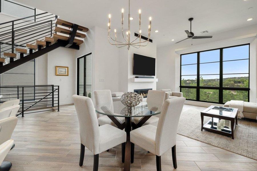 Open-concept living space featuring wood-finish flooring and a modern floating staircase with metal railings