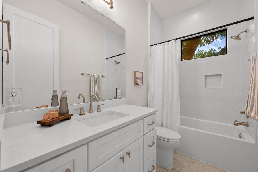 A well-lit bathroom features a spacious vanity with dual sinks, a large mirror, and a bathtub with a shower. A well-lit bathroom features a spacious vanity with dual sinks, a large mirror, and a bathtub with a shower.