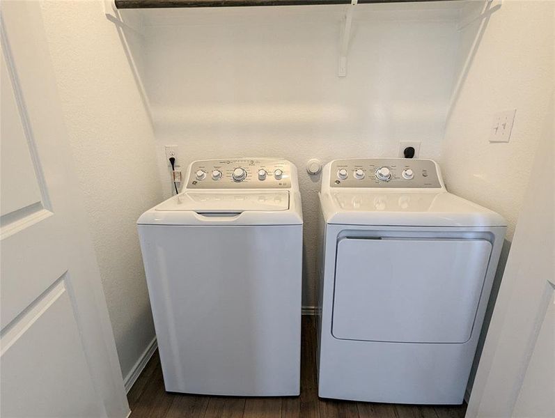 Functional laundry nook provides convenient in-home appliance access with overhead shelving.