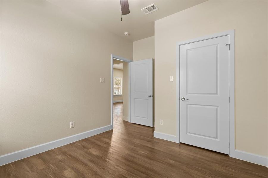 Unfurnished bedroom featuring dark hardwood / wood-style flooring and ceiling fan