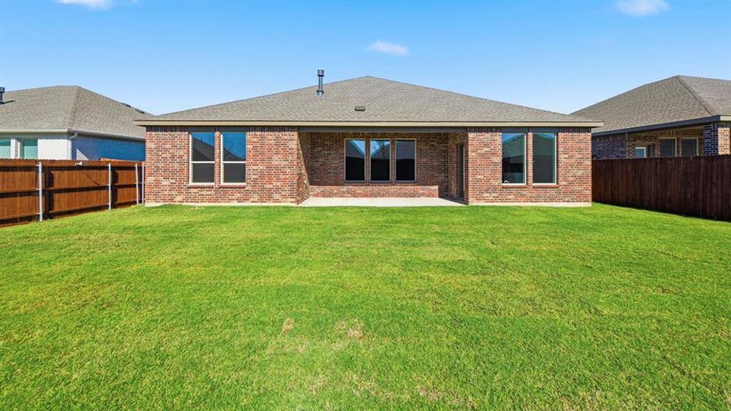 Rear view of house with roof with shingles, a patio area, a fenced backyard, and brick siding Rear view of house with roof with shingles, a patio area, a fenced backyard, and brick siding