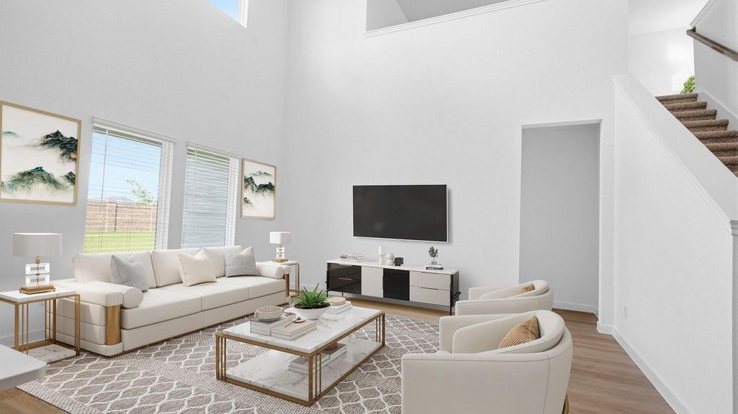 A luxurious living room featuring tall ceilings, large windows for natural lighting wood flooring and a view to the backyard. A luxurious living room featuring tall ceilings, large windows for natural lighting wood flooring and a view to the backyard.