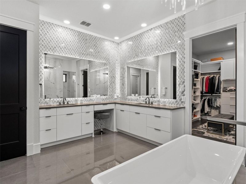 Full bath featuring a marble finish shower, double vanity, a walk in closet, recessed lighting, and a freestanding bath