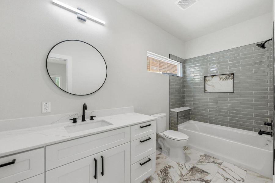 Bathroom featuring vanity,  shower combination, and light marble finish floors