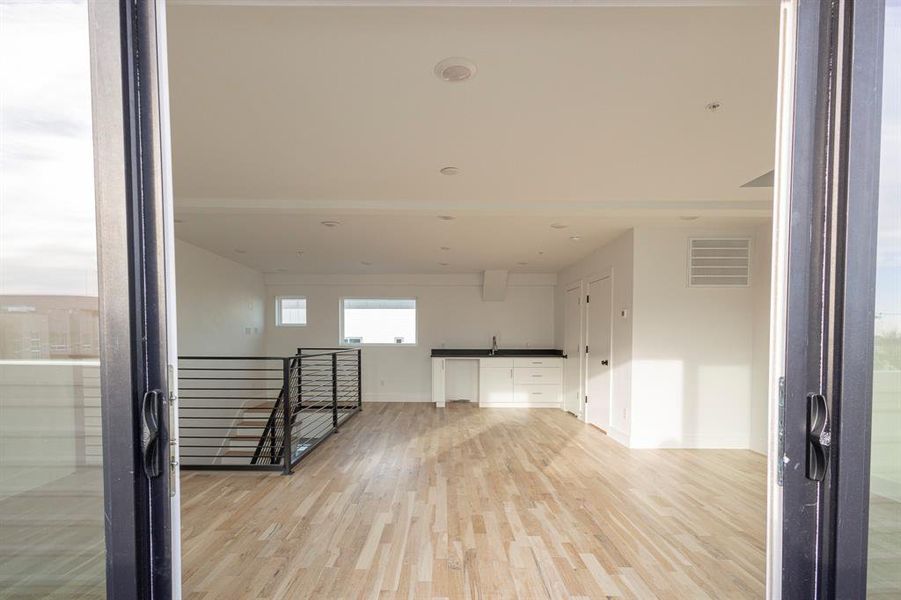 Unfurnished room with light wood finished floors, visible vents, and baseboards