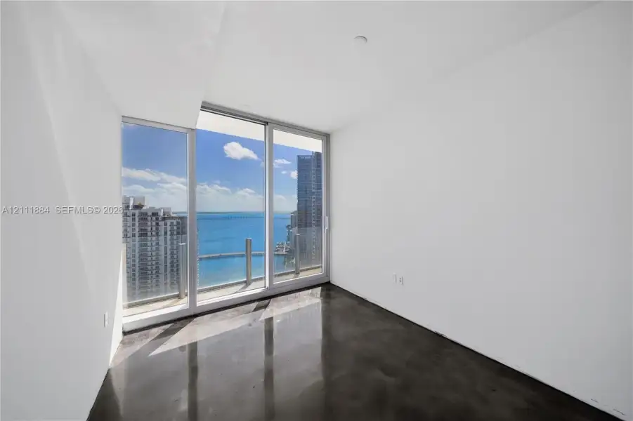Floor-to-ceiling windows, polished concrete flooring, and water-fronting balcony access Floor-to-ceiling windows, polished concrete flooring, and water-fronting balcony access