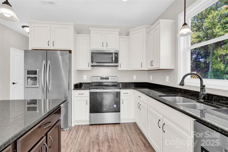 Spacious, Bright kitchen with island, lots of cabinet storage and counter top space.