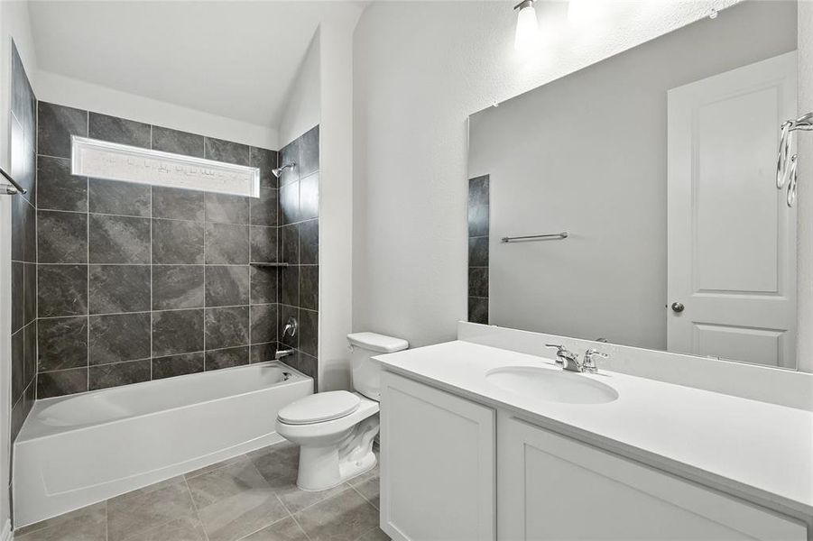 Bathroom featuring vanity, shower / washtub combination, and light tile patterned floors