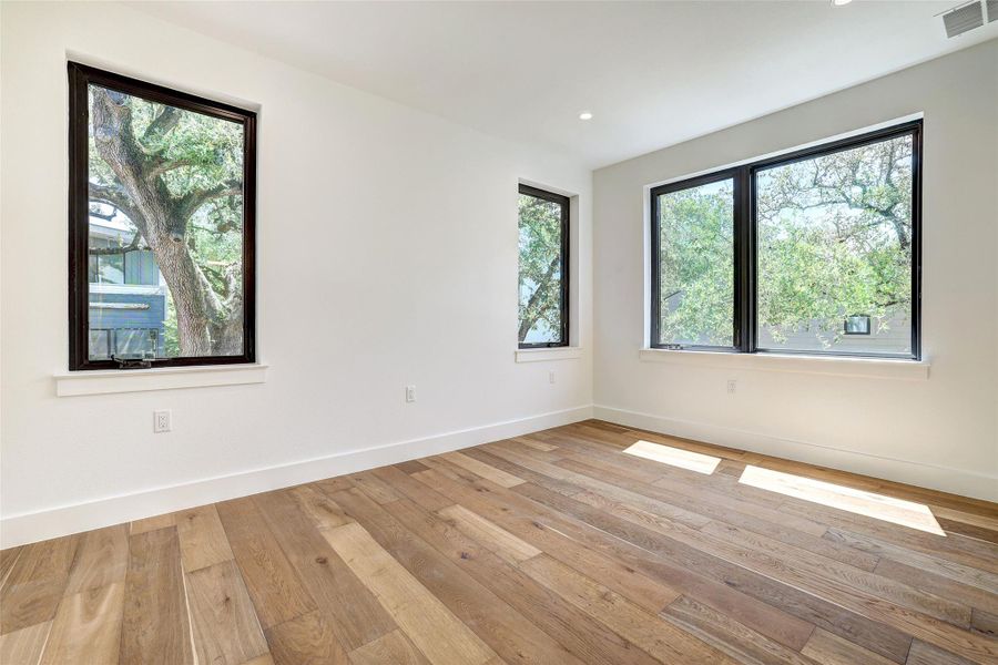Empty room with light wood-style flooring, baseboards, and recessed lighting