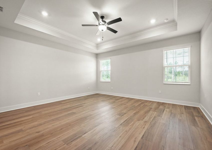 Master bedroom with fan and vinyl floors.