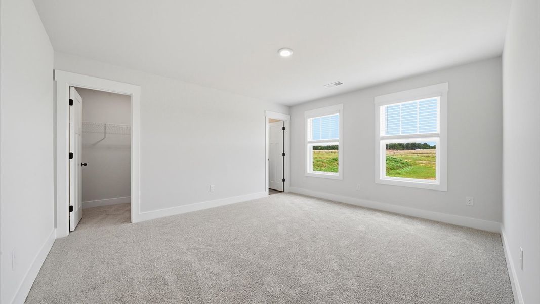 Highly functional bedroom with large windows, carpeted flooring, and tasteful finishes throughout in Woodruff, SC