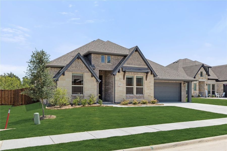 Single-story brick and stone home with two-car garage, pitched roof, and landscaped front yard Single-story brick and stone home with two-car garage, pitched roof, and landscaped front yard