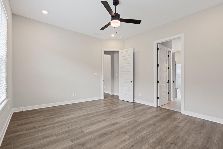 Spacious room featuring wood-finish flooring, light neutral wall tones, and white trim Spacious room featuring wood-finish flooring, light neutral wall tones, and white trim