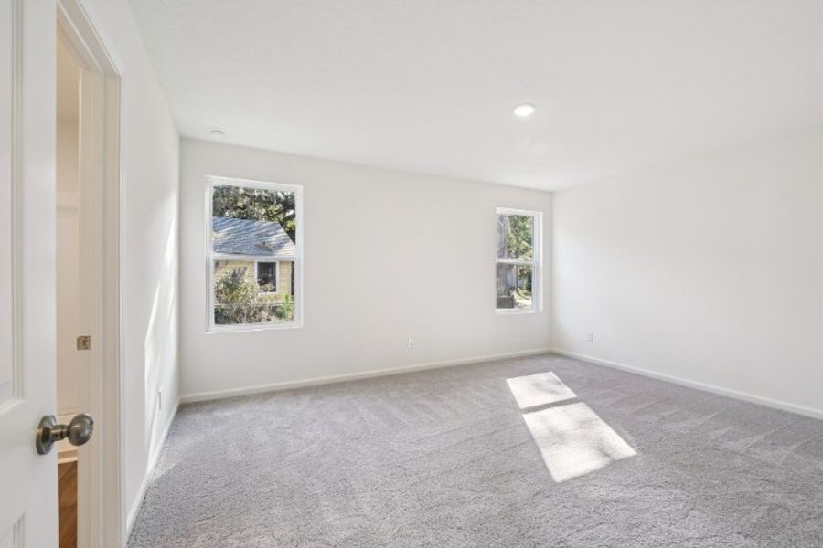 A room with a rug and pictures on the wall.