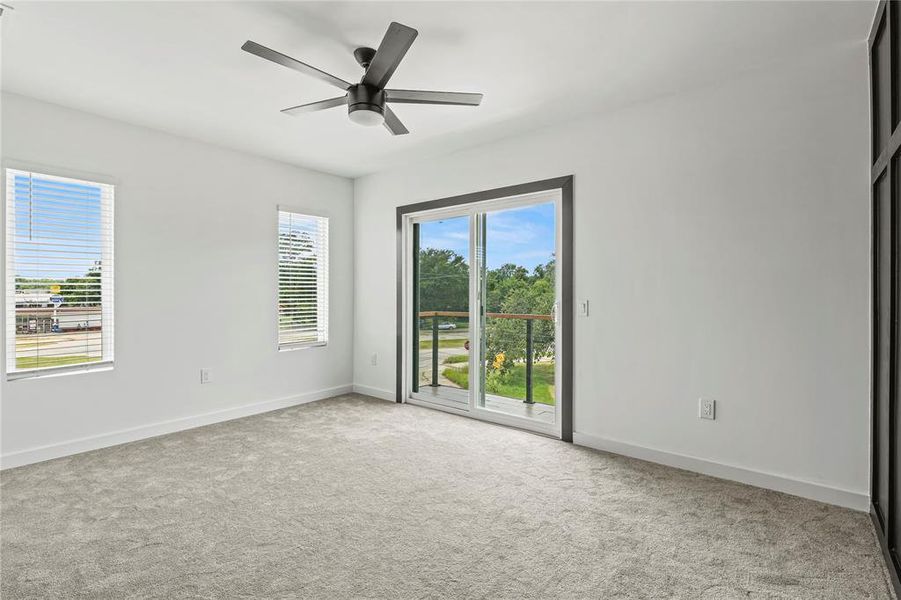Carpeted empty room with baseboards and a ceiling fan Carpeted empty room with baseboards and a ceiling fan