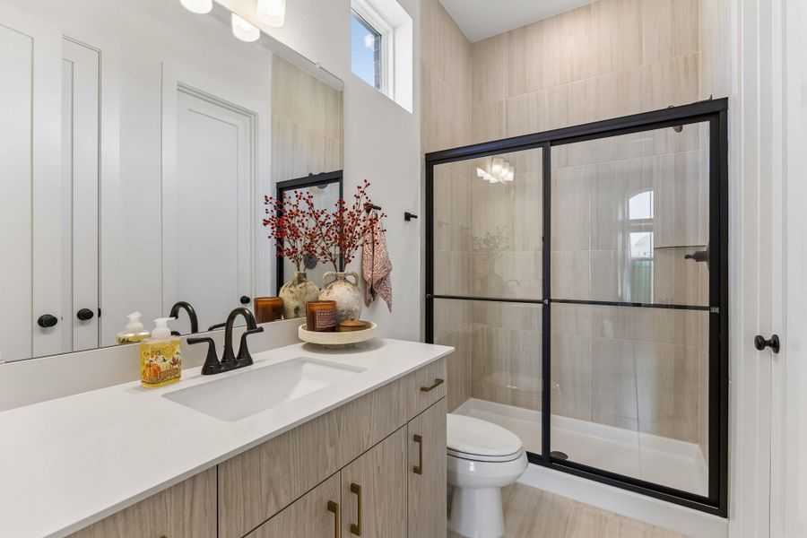 High ceilings and a glass-enclosed shower highlight this modern bathroom space.