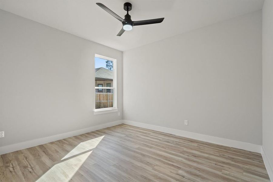 Unfurnished room with ceiling fan and light wood-type flooring