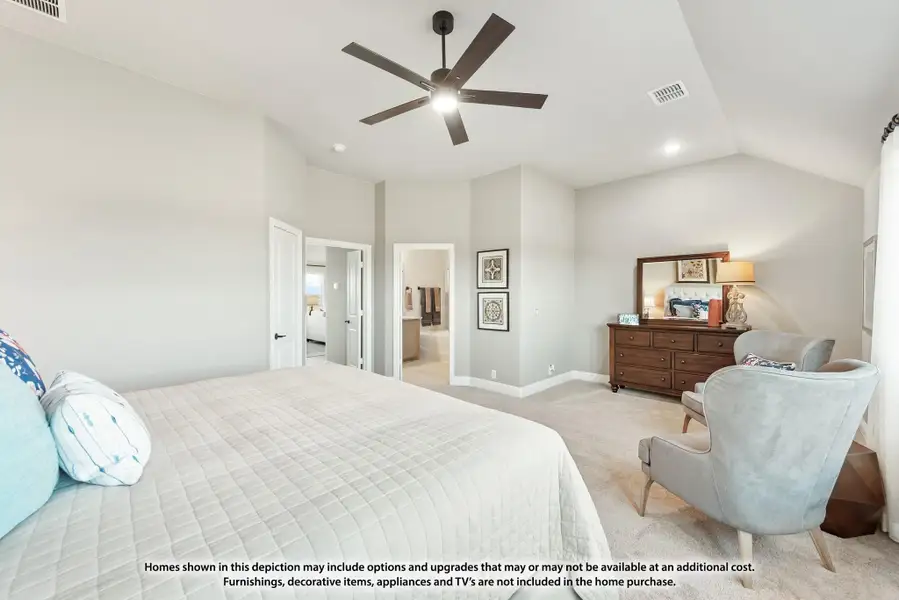 Spacious master bedroom with vaulted ceiling, ceiling fan, carpet flooring, and ensuite bathroom doorway visible. Spacious master bedroom with vaulted ceiling, ceiling fan, carpet flooring, and ensuite bathroom doorway visible.