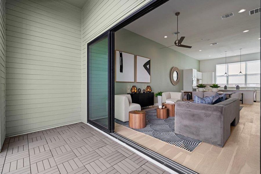 A seamless connection links the tiled outdoor patio to the hardwood living room inside. A seamless connection links the tiled outdoor patio to the hardwood living room inside.