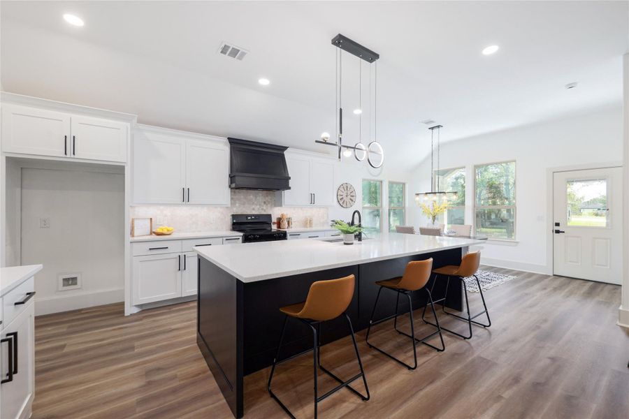 Kitchen with decorative backsplash, white cabinets, pendant lighting, recessed lighting, and a kitchen breakfast bar