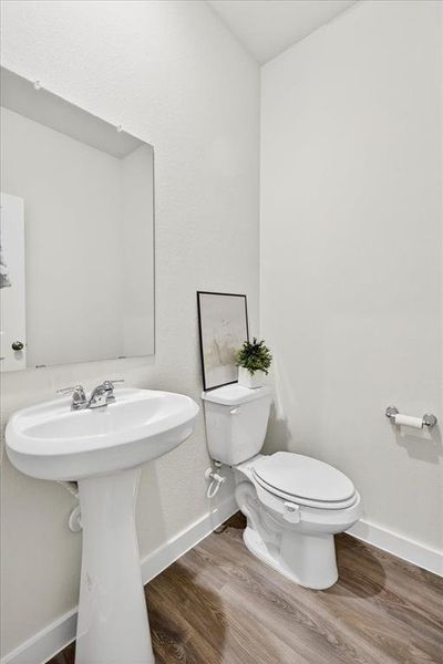 Half bath featuring a  sink and luxury vinyl flooring