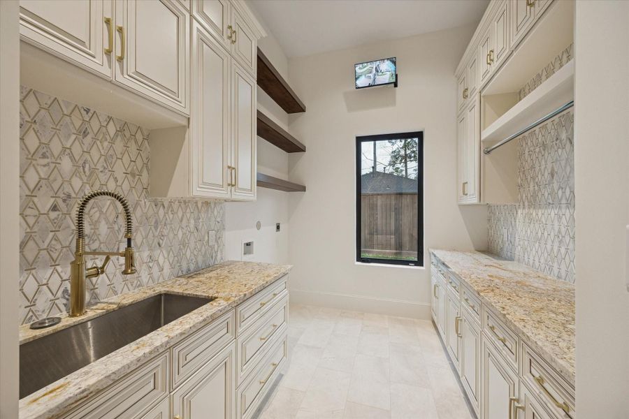 Will-appointed first-floor utility room features custom cabinetry, extenstive storage, a secondary refrigerator, and abundant workspace designed for everyday convenience. Will-appointed first-floor utility room features custom cabinetry, extenstive storage, a secondary refrigerator, and abundant workspace designed for everyday convenience.