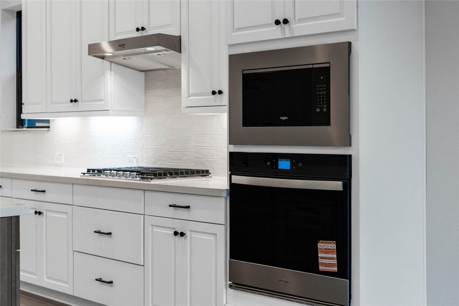 This Whirlpool stainless steel appliance suite offers a high-performance, integrated cooking experience within a modern kitchen setting.