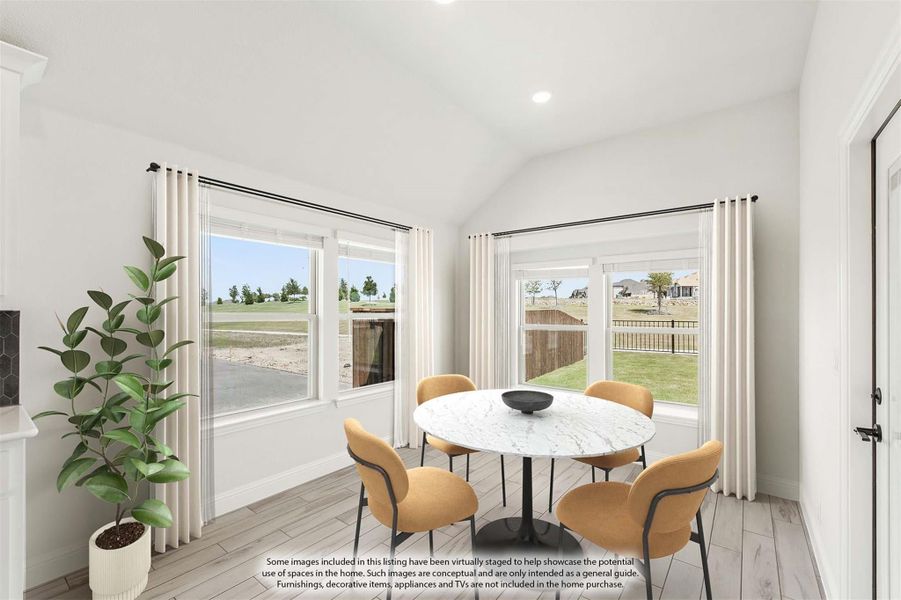 Bright dining nook with round marble table, four chairs, vaulted ceiling, and large windows overlooking backyard