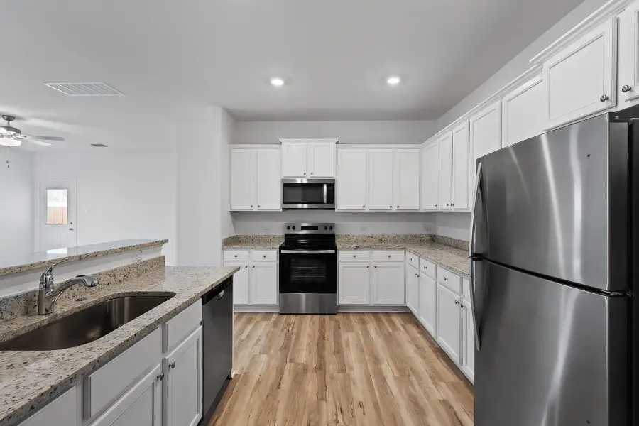 In the kitchen of this home, you’ll find a full suite of energy-efficient Whirlpool® appliances, including the refrigerator, spacious granite countertops, 36” upper wood cabinets with crown molding and a USB charging outlet.