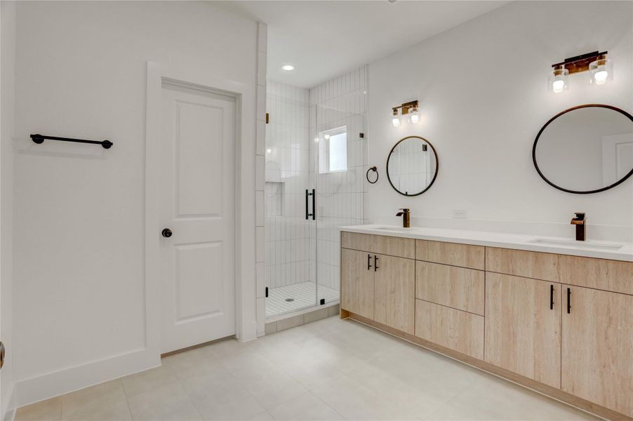 The primary bath has solid wood cabinets, custom lighting, 3cm quartz counters, and custom fixtures.