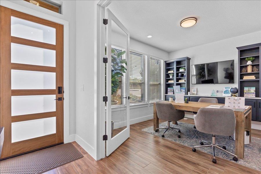 Office featuring light wood-style flooring and built in shelves