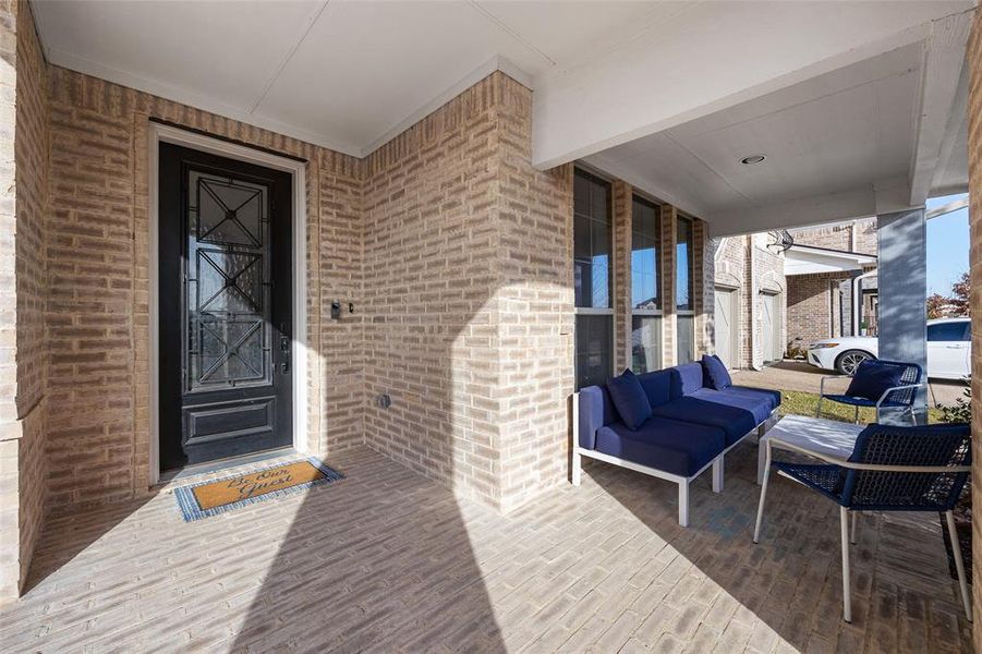 Property entrance with brick siding and an outdoor hangout area