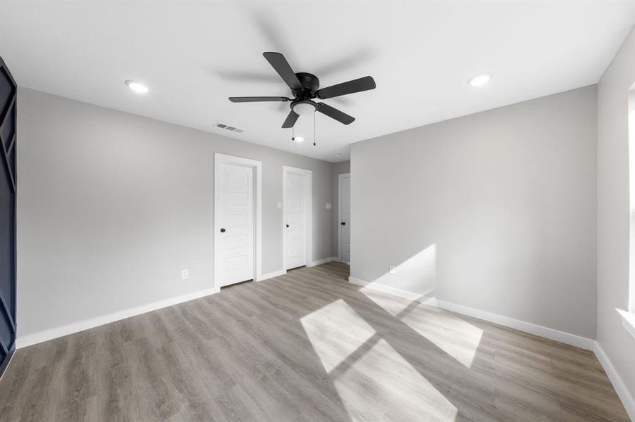 Unfurnished bedroom with light wood-style floors, ceiling fan, and recessed lighting Unfurnished bedroom with light wood-style floors, ceiling fan, and recessed lighting