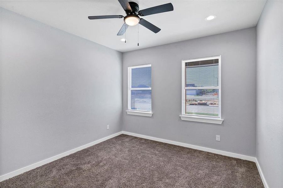 Spare room featuring carpet flooring and ceiling fan