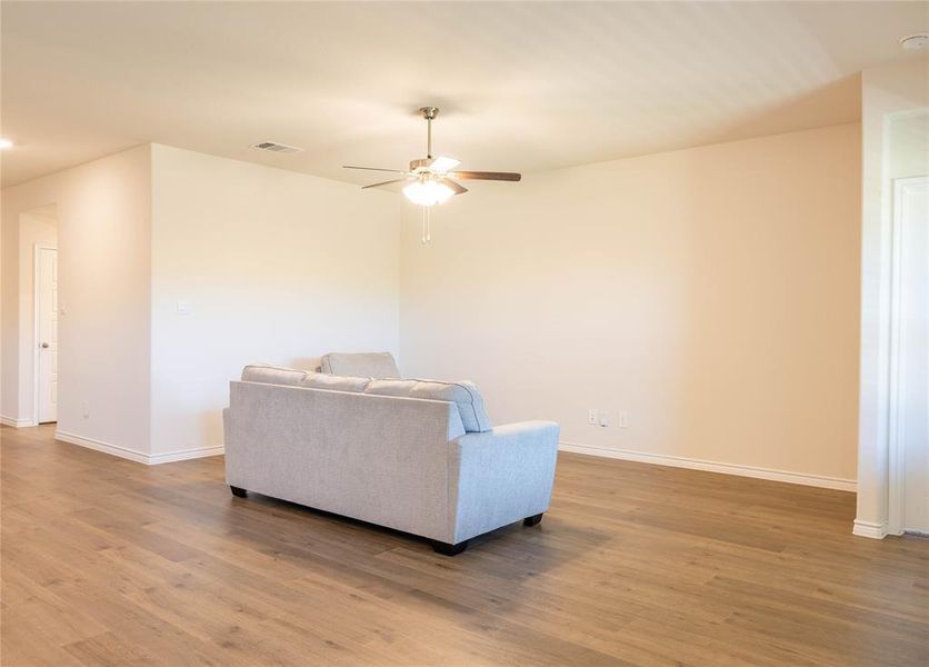 Living room featuring wood finished floors, a ceiling fan, and recessed lighting Living room featuring wood finished floors, a ceiling fan, and recessed lighting