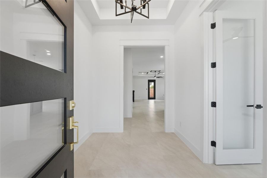 Step inside to a bright, open foyer with 11-ft ceilings, oversized tile floors, sleek modern fixtures, and all the natural light you could dream of.