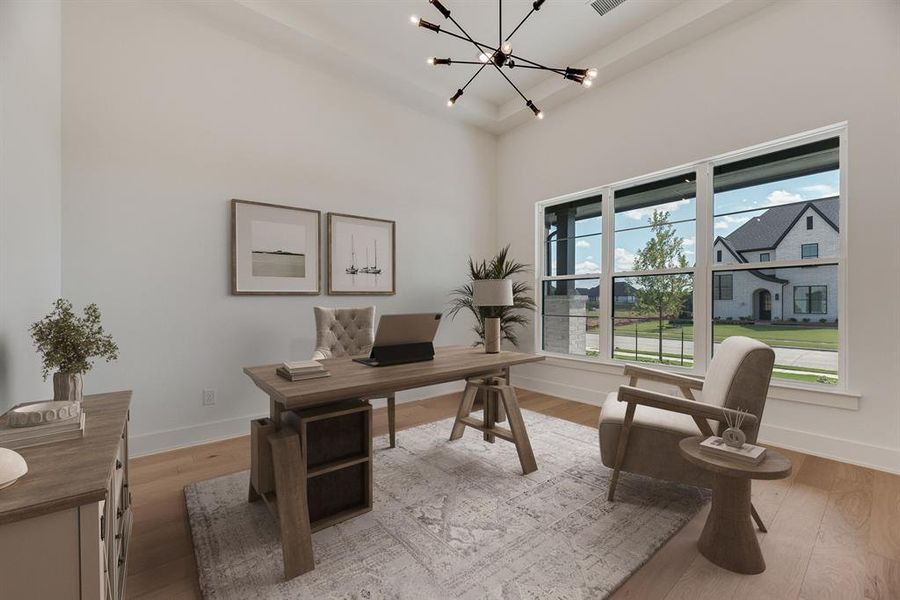 Office space with light wood-type flooring, a chandelier, and a high ceiling