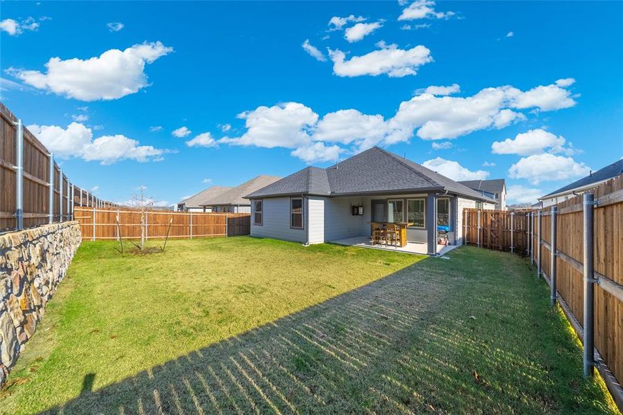 Back of property featuring a yard and a patio