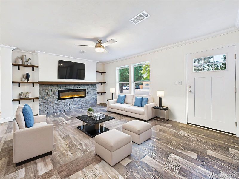 Virtually Staged Striking floor-to-ceiling stone electric fireplace with wood mantel and built-in shelving.