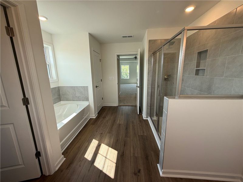 A well-lit bathroom showcases a spacious tub and a A well-lit bathroom showcases a spacious tub and a