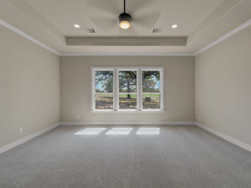 Carpeted empty room featuring ornamental molding, a tray ceiling, a ceiling fan, and recessed lighting Carpeted empty room featuring ornamental molding, a tray ceiling, a ceiling fan, and recessed lighting