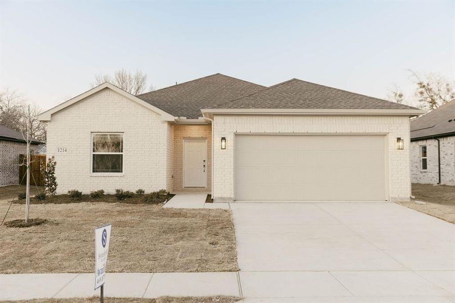 Ranch-style house with roof with shingles, brick siding, driveway, and an attached garage