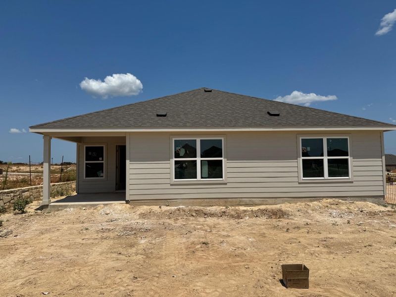 Back of property with roof with shingles and a patio
