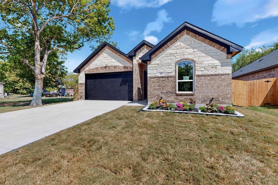 French provincial home featuring driveway, a garage, and brick siding