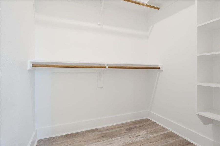 Walk in closet featuring  wood-type flooring