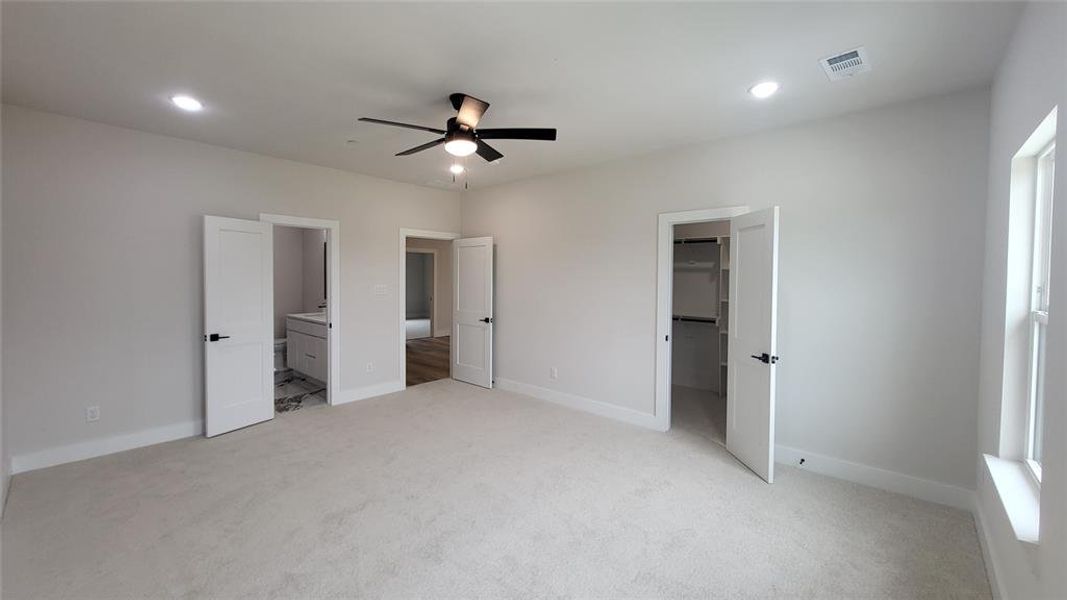 Unfurnished bedroom with light carpet, baseboards, visible vents, a spacious closet, and recessed lighting