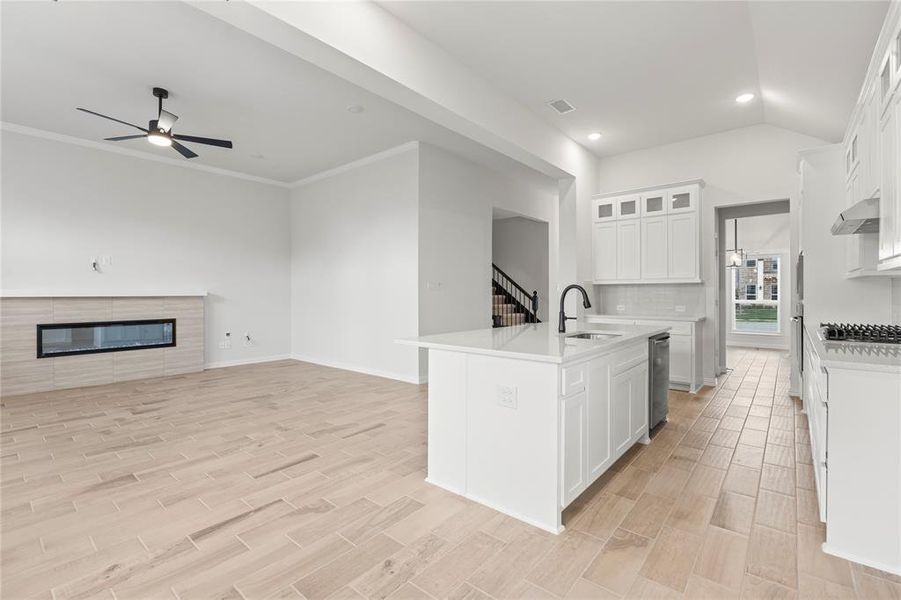 Kitchen with sink, a kitchen island with sink, white cabinetry, ceiling fan, and wall chimney exhaust hood